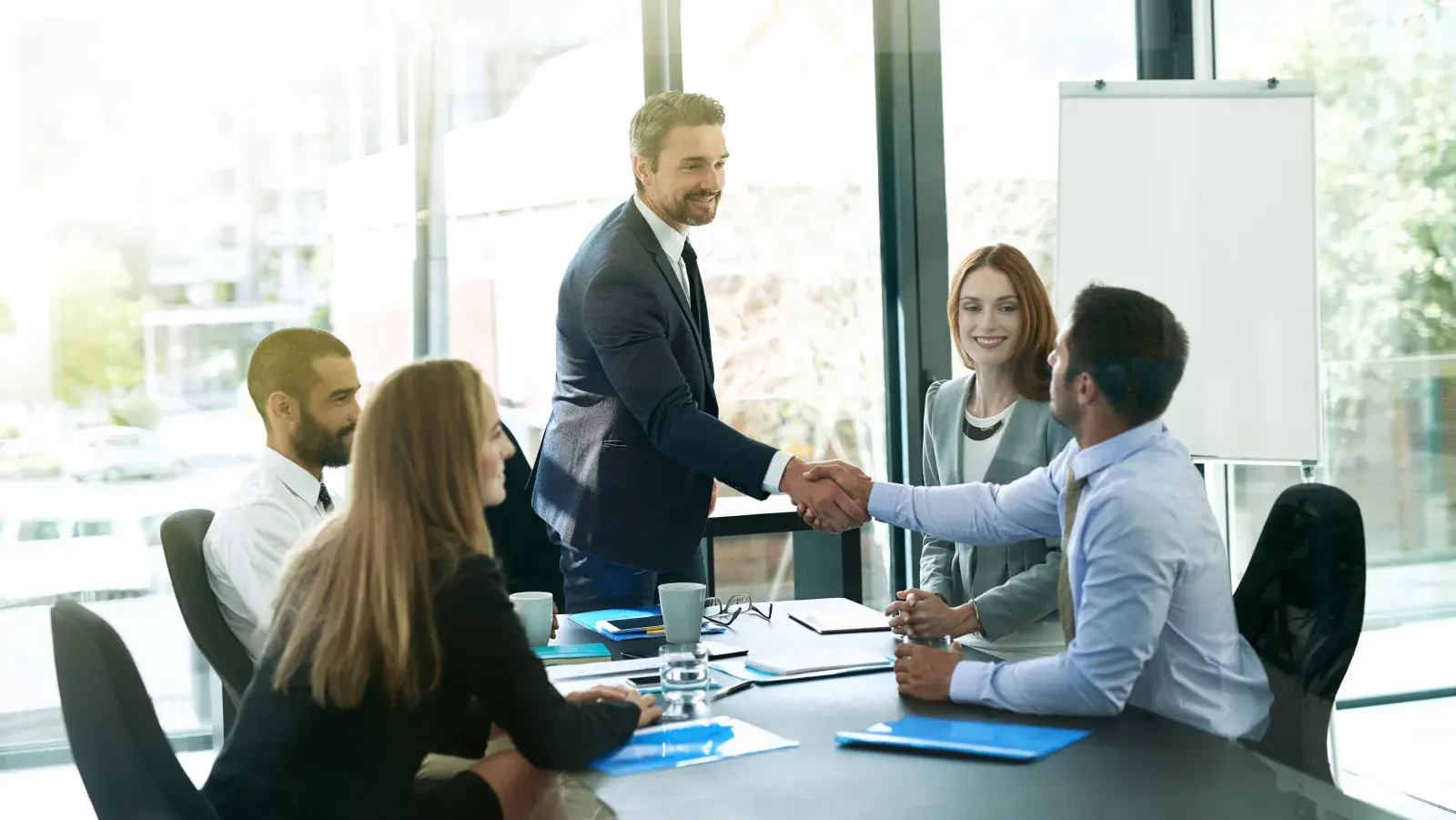 Reunião executiva com aperto de mãos em ambiente corporativo